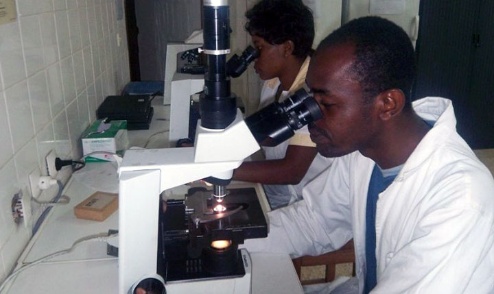Mann am Mikroskop im Labor